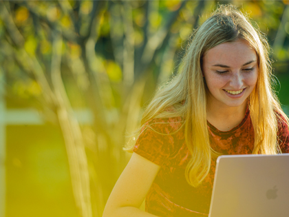 Student working on laptop outside