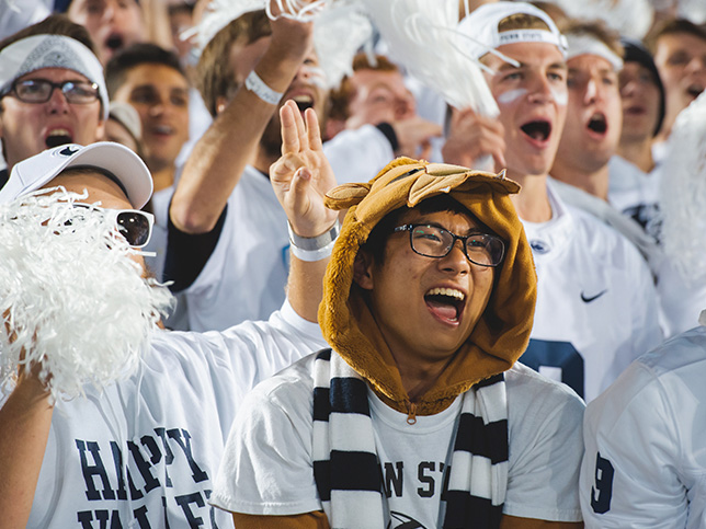 A crowd of students cheering and wearing Penn State White Out shirts